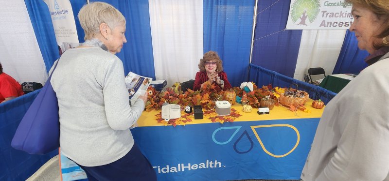 Bevereley Stoakley of Tidal Health Lifeline answers questions from a visitor to her booth at the 55+ Expo.
